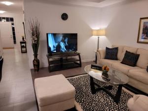 a living room with a couch and a tv at Deluxe 3 Bedroom near Hyde Park mall & Western Uni in London