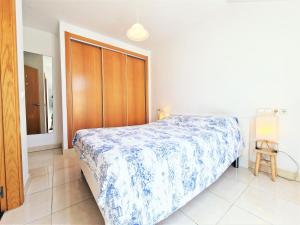 a bedroom with a bed and a wooden closet at AA Guest - Salinas Paradise Terrace Eco Apartment in Fuengirola