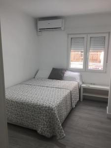 ein weißes Schlafzimmer mit einem Bett und zwei Fenstern in der Unterkunft NEW STYLISH BEACH FRONT APARTMENT in Cullera