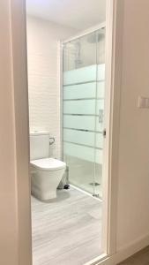 a bathroom with a toilet and a glass shower at NEW STYLISH BEACH FRONT APARTMENT in Cullera