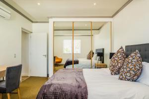 a bedroom with a bed and a desk and a mirror at Majolica in Cape Town