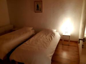 1 dormitorio con 1 cama y 1 mesa con lámpara en Maison-indi, en Houffalize