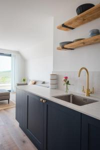 a kitchen with blue cabinets and a sink at Apartment 14, Withie Cove in Hope Cove