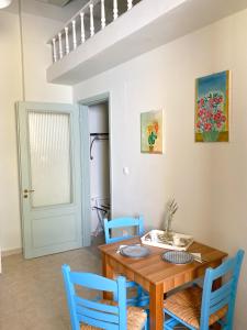 comedor con mesa de madera y sillas azules en Arsanas, en Symi 40 fotos más