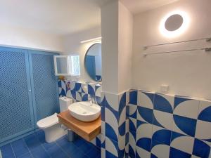 Un baño azul y blanco con lavabo e inodoro. en Arsanas, en Symi