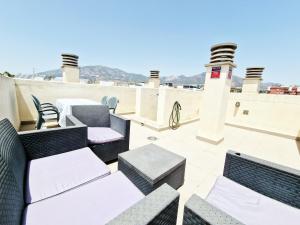 a patio with chairs and tables on a roof at AA Guest - Salinas Paradise Terrace Eco Apartment in Fuengirola