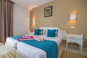 TMK Marine Beach - All Inclusive Seafront resort في طريفة: غرفة نوم بسريرين باللونين الأزرق والأبيض