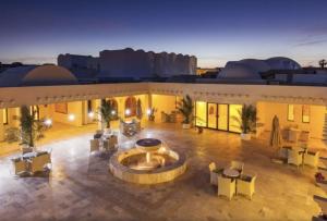 an outdoor patio with a fountain in the middle of a building at TMK Marine Beach - All Inclusive Seafront resort in Triffa