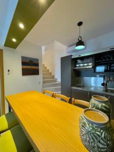 a dining room with a wooden table and chairs at Koumaros Aparthotel in Agia Paraskevi