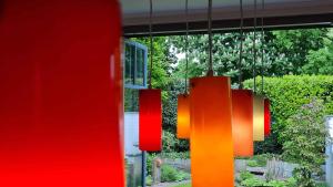 a group of red and orange chandeliers hanging from a house at Kleine Oase in Bottrop