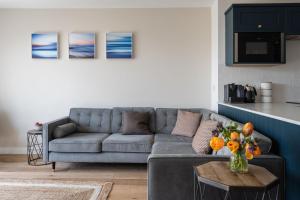 uma sala de estar com um sofá cinzento e uma mesa em Apartment 7, Elender Cove em Hope-Cove