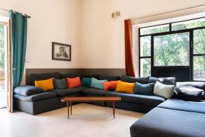een woonkamer met een bank en kleurrijke kussens bij Maison d’Etienne in Lacoste