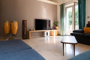 ein Wohnzimmer mit einem Sofa und einem TV in der Unterkunft Maison d’Etienne in Lacoste