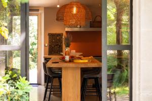 una cocina con una mesa de madera con sillas alrededor. en Maison d’Etienne en Lacoste