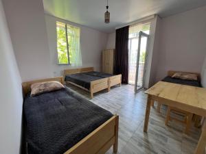 a room with two beds and a table and windows at Batita in Kobuleti