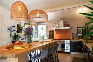 a kitchen with a large wooden island with bar stools at Maison d’Etienne in Lacoste
