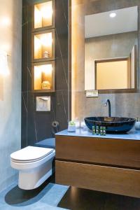 ein Badezimmer mit einem Waschbecken, einem WC und einem Spiegel in der Unterkunft hotelise I Leo Apartment in Yerevan
