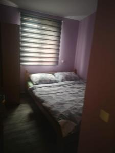 uma cama num quarto com uma janela num quarto em Apartmani Betina - Petra Preradovića 2K em Betina