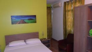 a bedroom with a bed and a yellow wall at Sunway Residence in Mont Choisy