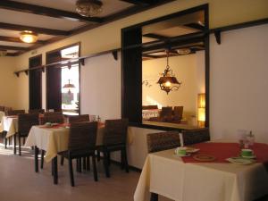 a dining room with tables and chairs and a mirror at Hotel Tanneneck in Bad Bramstedt