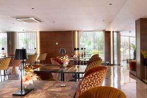 a dining room with tables and chairs and windows at Exe Parc del Vallés in Cerdanyola del Valles