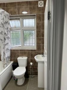 Captivating 2-Bed Apartment in Ilford في إلفورد: حمام مع مرحاض ومغسلة