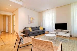 a living room with a couch and a tv at Velazquez Suites in Madrid