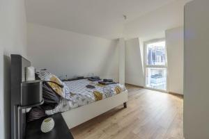 ein Schlafzimmer mit einem Bett und einem großen Fenster in der Unterkunft Les Jardins d'Aix in Aix-les-Bains