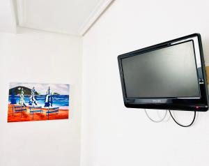 Hotel Zarauz في زاروتز: تلفزيون بشاشة مسطحة معلق على جدار مع صورة