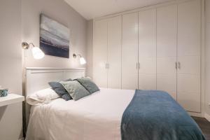 a white bedroom with a bed and white cabinets at Castellana Suites in Madrid