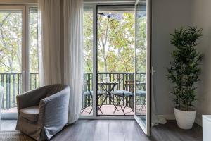 a living room with a chair and a balcony at Castellana Suites in Madrid