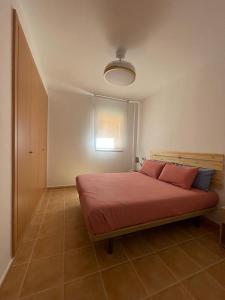 Un dormitorio con una cama con sábanas rojas y una ventana en LyriosHomes Marina de la Torre Beach, en Mojácar