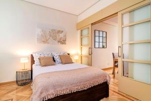 - une chambre avec un grand lit et une porte coulissante en verre dans l'établissement Velazquez Suites, à Madrid