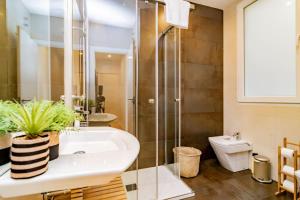 łazienka z prysznicem, umywalką i toaletą w obiekcie Juan Bravo Suites w Madrycie