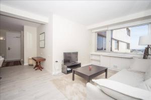 a living room with a white couch and a table at Colon Suites in Madrid