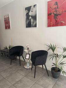カンヌにあるホテル アンナ リヴィアの椅子2脚とテーブル付きの待合室
