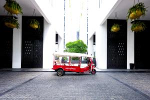 een kleine rode auto geparkeerd voor een gebouw bij Mövenpick Hotel Sukhumvit 15 Bangkok in Bangkok