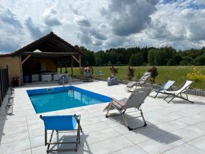 a patio with chairs and a swimming pool at Koniec Świata dom 84m2 z balią i basenem na wyłączność in Mikołajki