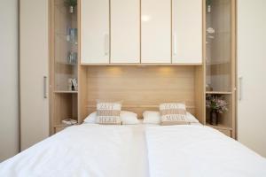 1 dormitorio con 2 camas y armarios blancos en Haffkamp 14, en Grömitz