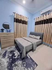 En eller flere senge i et værelse på Homestay Jeli - Cattleya Inn Muslim