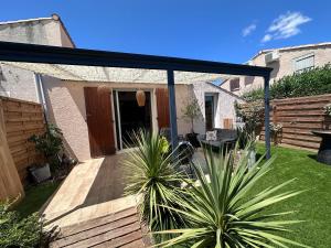 d'une terrasse avec un auvent noir dans la cour. dans l'établissement Petite maison, à Vic-la-Gardiole