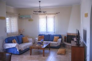 基普塞利的住宿－Villa Hestia，客厅配有蓝色的沙发和桌子