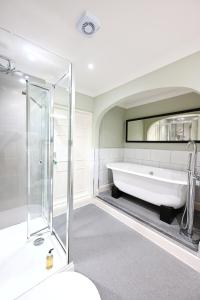 a bath tub in a bathroom with a mirror at Dovey Inn in Aberdyfi