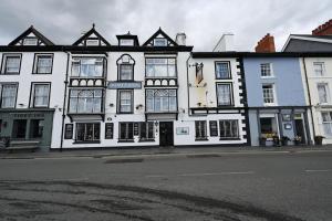 um edifício branco e preto na esquina de uma rua em Dovey Inn em Aberdyfi