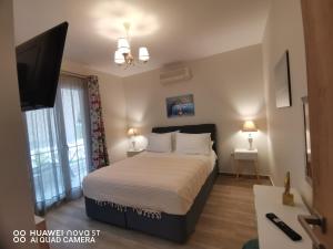 a bedroom with a bed and a flat screen tv at Nely's Luxury Home in Nydri