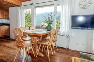 a dining room with a table and chairs and a tv at Casa LA RODA in Sedrun