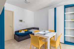 a living room with a table and chairs and a couch at Calanca Apulian Residence in Torre Santa Sabina