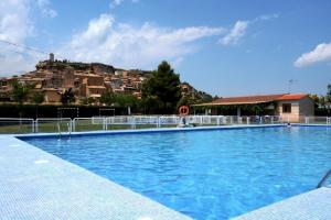 a large swimming pool with a hill in the background at Apartamento La Placeta in Monroyo