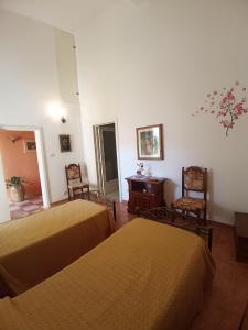 Habitación con 2 camas, mesa y sillas en Casa vacanza Il Giardino, en Supersano