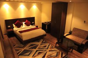 ein Schlafzimmer mit einem Bett und einem Stuhl in einem Zimmer in der Unterkunft AERO HOTEL BY AERO LOUNGE AND BAR in Kathmandu